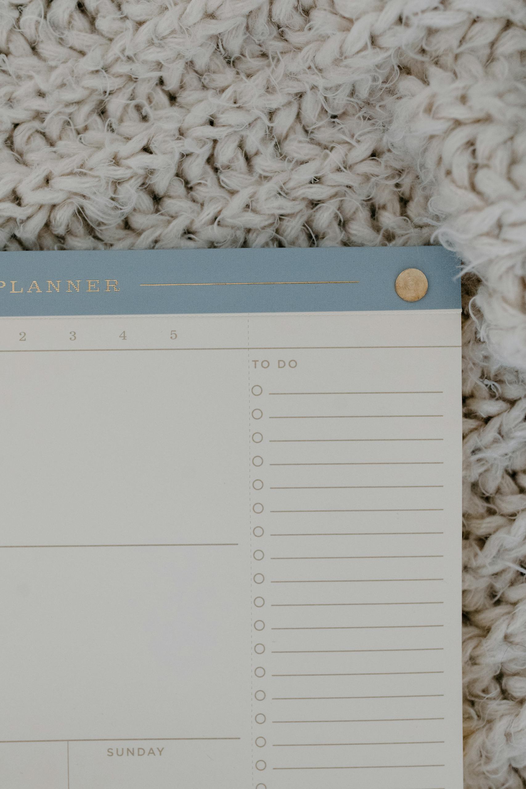 Flat lay photograph of a minimalist to-do planner on a textured background.